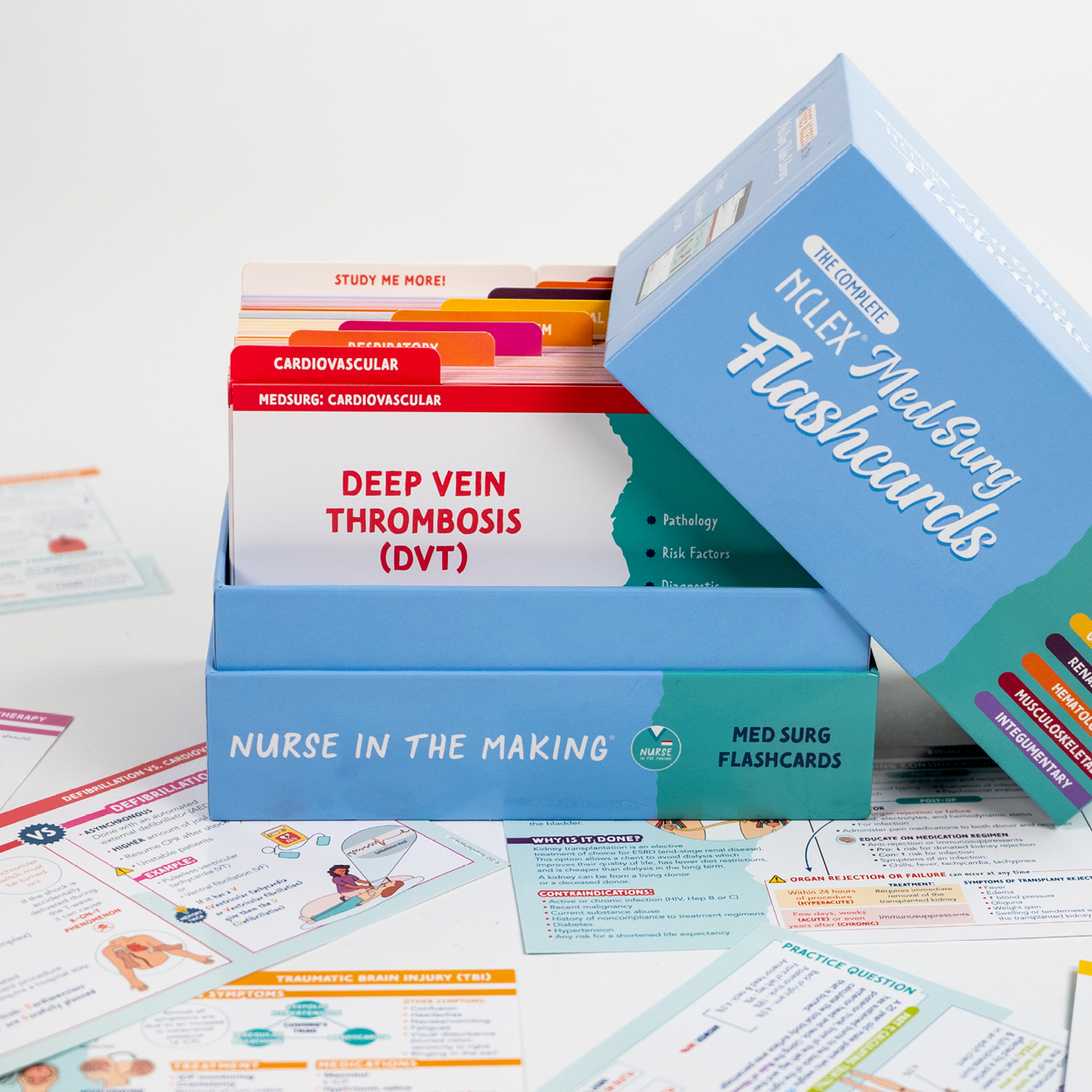 An open box of “NCLEX Med Surg Flashcards” from Nurse in the Making is displayed with flashcards inside, one labeled “Deep Vein Thrombosis (DVT).” The blue box has a tilted lid, revealing neatly organized cards with color-coded tabs. Additional study flashcards are scattered around on a white surface.
