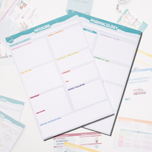 A set of Med-Surg and Pharmacology notepads designed for nursing students is displayed on a white background with study materials scattered around. The notepads feature structured sections for organizing disease pathophysiology, signs and symptoms, potential complications, nursing interventions, medication mechanisms of action, therapeutic uses, and patient education. These templates help students efficiently organize key medical information for studying and clinical practice.