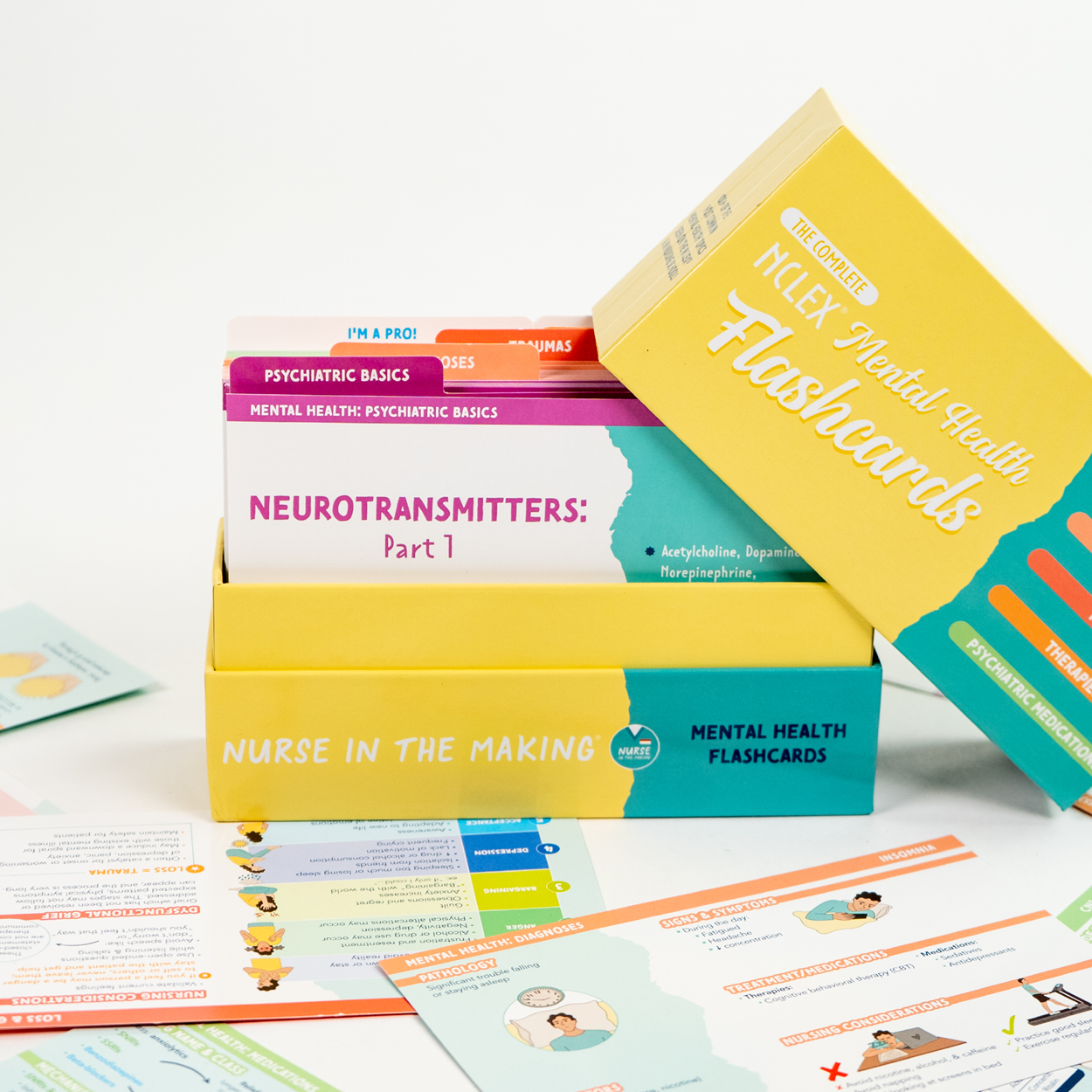 A box of NCLEX Mental Health Flashcards from Nurse in the Making is open, revealing neatly organized flashcards inside. The flashcards are categorized into sections such as Psychiatric Basics, Neurotransmitters, Diagnosis, Traumas, Therapies, and Psychiatric Medications. Additional flashcards are laid out in front, featuring illustrations and key concepts designed to help nursing students review mental health topics and pharmacology.